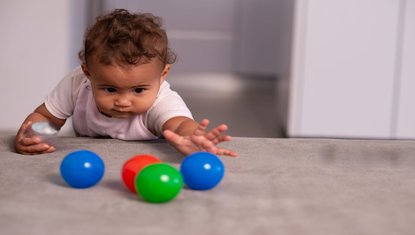 תינוק משחק בכדורים צבעוניים משחק מעודד זחילה מפתח סקרנות ותנועה