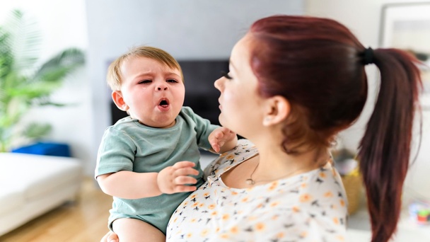 אמא מחזיקה ילד חולה בידיים מחלת הפה והגפיים מופיעה בעיקר בגיל הרך