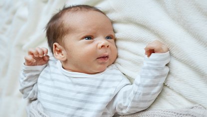 תינוק קטן שוכב על שמיכה