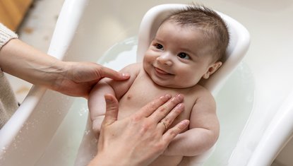 הורים רוחצים תינוק קטן בבית
